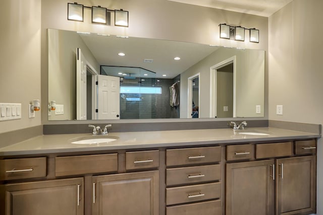 bathroom featuring double vanity, a stall shower, and a sink