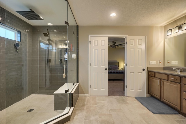 bathroom with vanity, tiled shower, ceiling fan, ensuite bathroom, and a textured ceiling