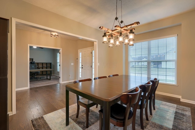 dining area featuring baseboards, an inviting chandelier, and dark wood finished floors