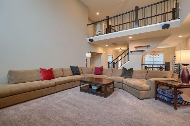 carpeted living room featuring stairway, recessed lighting, an inviting chandelier, and a towering ceiling