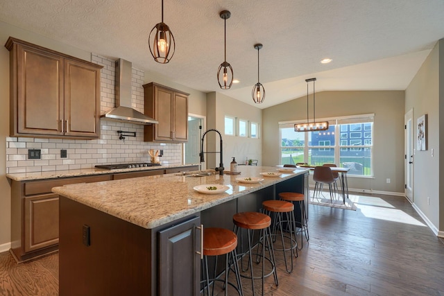5511 Timber Heights Ln, Grove City, OH 43123 - kitchen featuring wall chimney range hood, tasteful backsplash, stainless steel gas cooktop, a sink, and dark wood-style floors