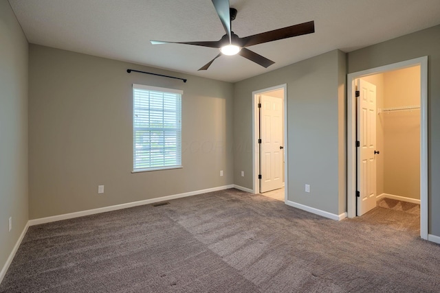 5511 Timber Heights Ln, Grove City, OH 43123 - unfurnished bedroom with a walk in closet, a ceiling fan, visible vents, baseboards, and carpet