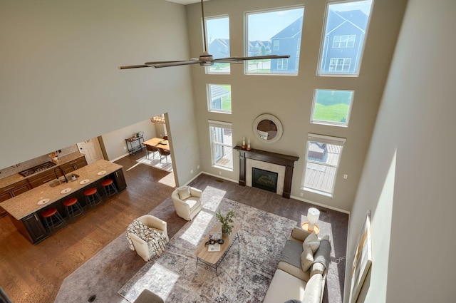 5511 Timber Heights Ln, Grove City, OH 43123 - living room featuring a fireplace, a ceiling fan, baseboards, wood finished floors, and a towering ceiling