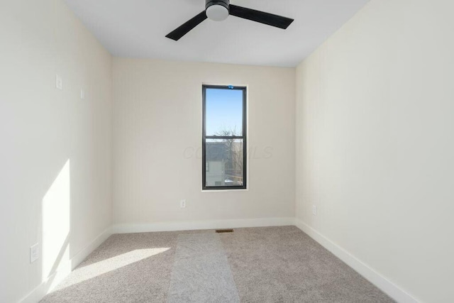 empty room featuring baseboards, carpet floors, visible vents, and a ceiling fan