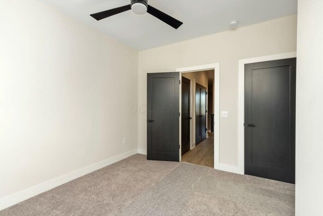 unfurnished bedroom featuring carpet flooring, a ceiling fan, and baseboards