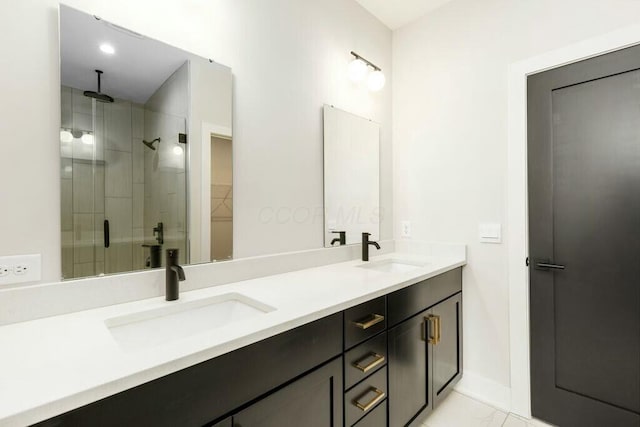 bathroom with a sink, a spacious closet, a stall shower, and double vanity