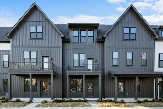 back of property featuring a porch, a shingled roof, a balcony, and board and batten siding