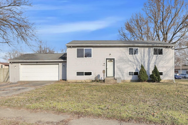 bi-level home featuring entry steps, a front lawn, an attached garage, and driveway