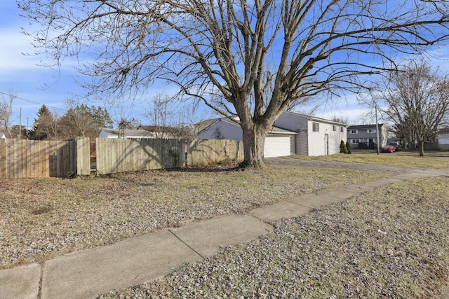 view of side of property featuring a garage, fence, and brick siding