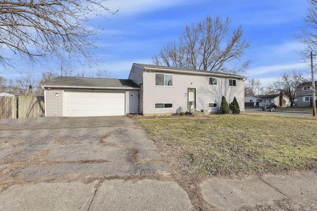 split foyer home with driveway, a front lawn, an attached garage, and fence