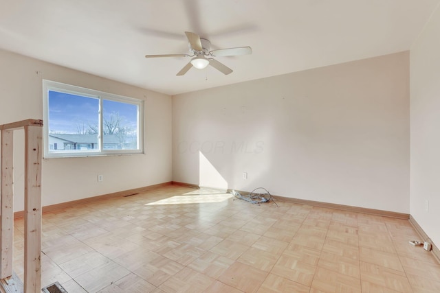 empty room featuring baseboards and ceiling fan