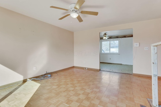 spare room featuring baseboards and ceiling fan