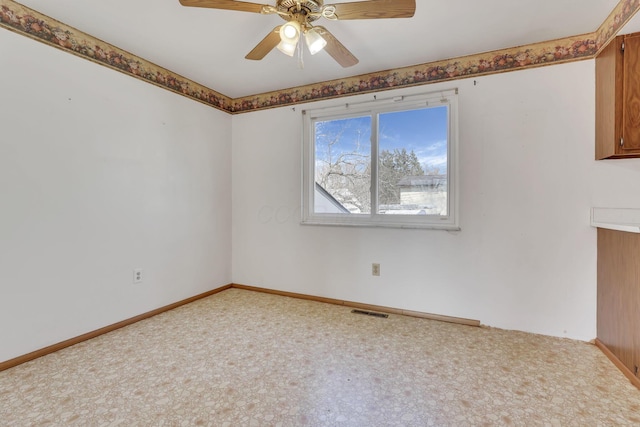 carpeted empty room with visible vents, baseboards, and a ceiling fan