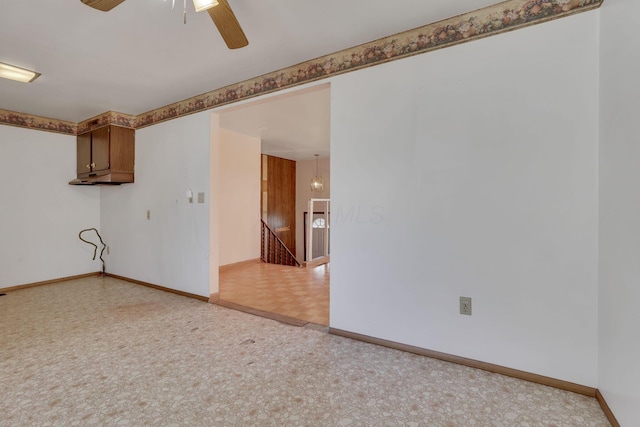 empty room with a ceiling fan and baseboards