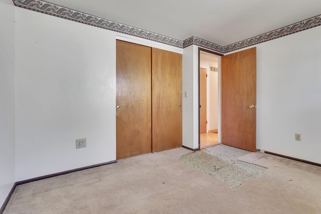 unfurnished bedroom with visible vents, carpet flooring, baseboards, and a closet