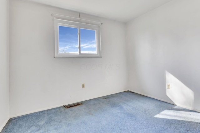 carpeted empty room featuring visible vents and baseboards