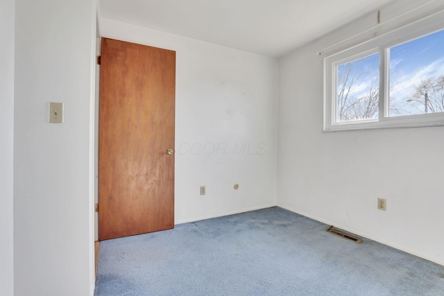 spare room with visible vents, baseboards, and carpet