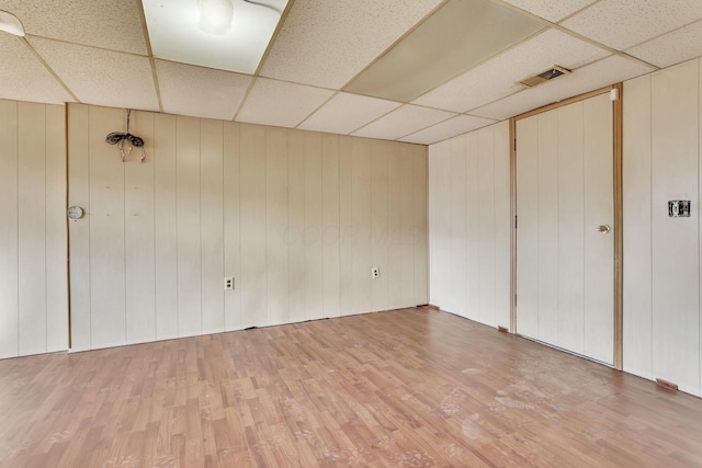 empty room with visible vents, a paneled ceiling, and light wood finished floors