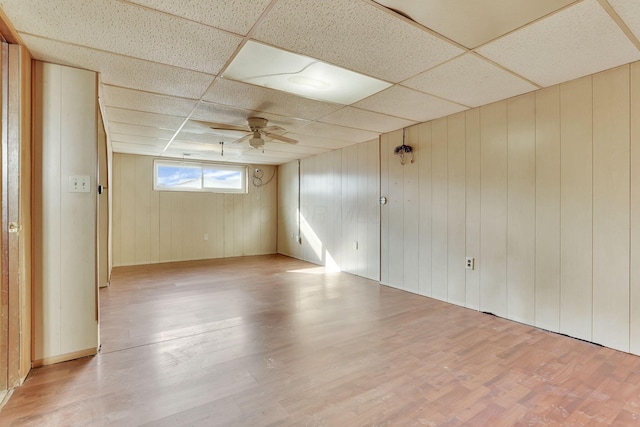 unfurnished room with light wood-type flooring, a paneled ceiling, and a ceiling fan