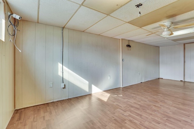 spare room featuring ceiling fan, a drop ceiling, and wood finished floors