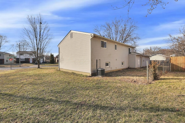 view of side of property with fence and a lawn