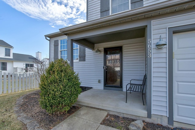 doorway to property with a garage and fence