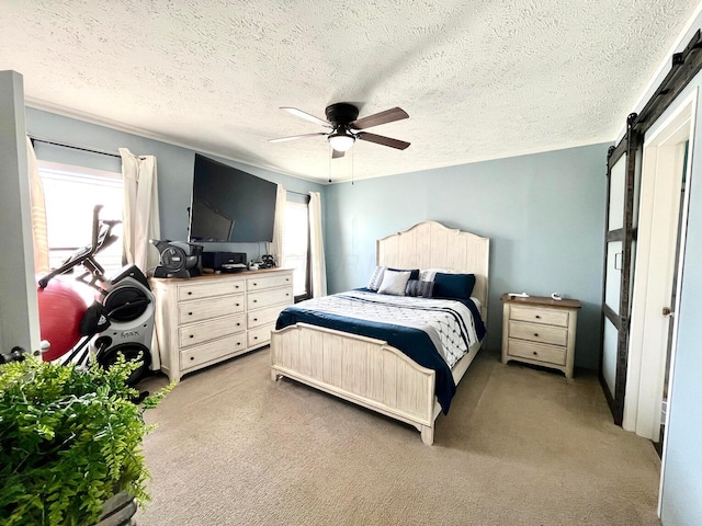 carpeted bedroom featuring a textured ceiling, a barn door, and ceiling fan