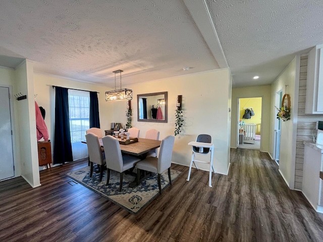 dining room with dark wood-style floors, a notable chandelier, and a textured ceiling