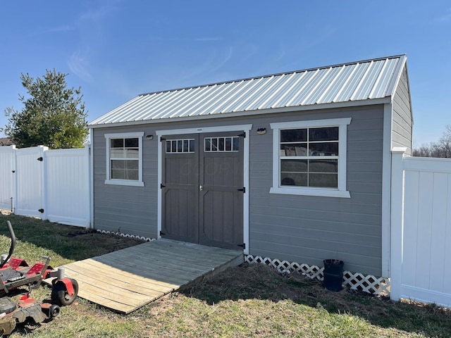 view of shed featuring a fenced backyard and a gate