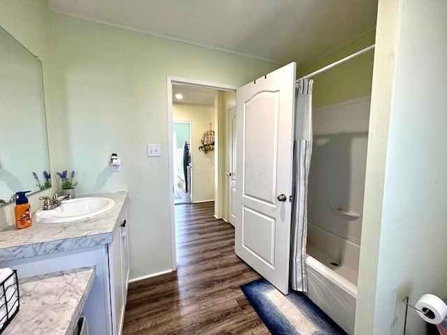 bathroom with vanity, shower / bath combo with shower curtain, baseboards, and wood finished floors