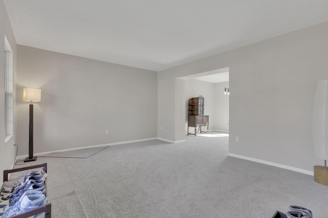 carpeted living area featuring baseboards