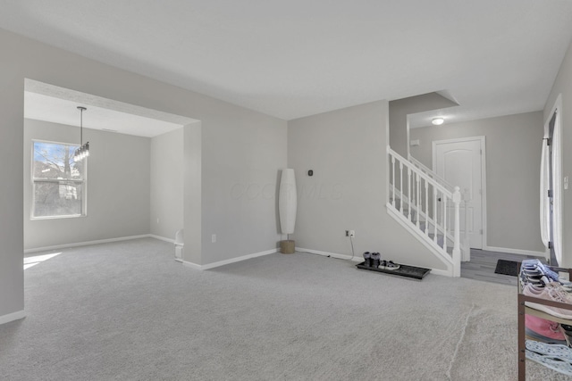 basement featuring stairs, an inviting chandelier, baseboards, and carpet floors