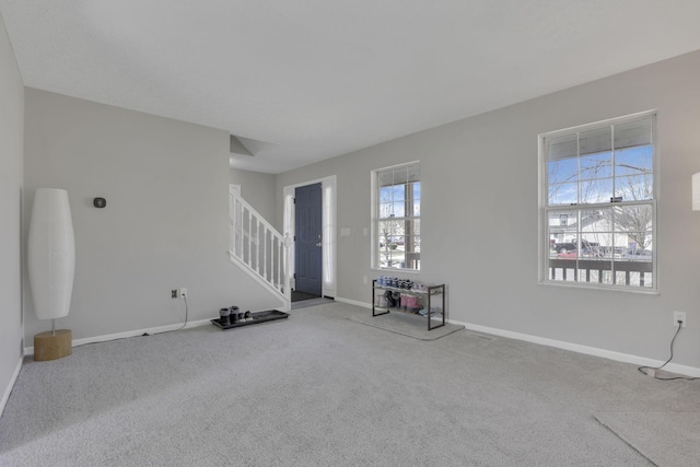 unfurnished living room with stairs, baseboards, and carpet floors