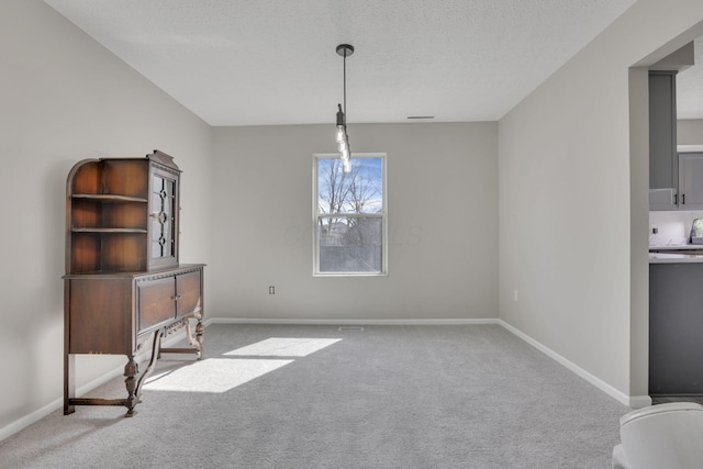 dining space featuring carpet flooring, visible vents, a textured ceiling, and baseboards