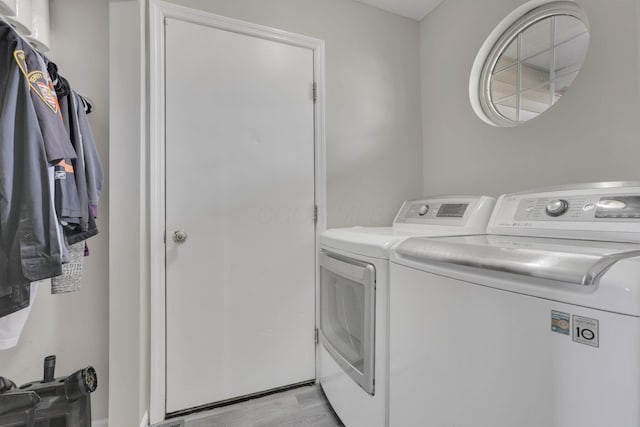 washroom featuring light wood-type flooring, separate washer and dryer, and laundry area