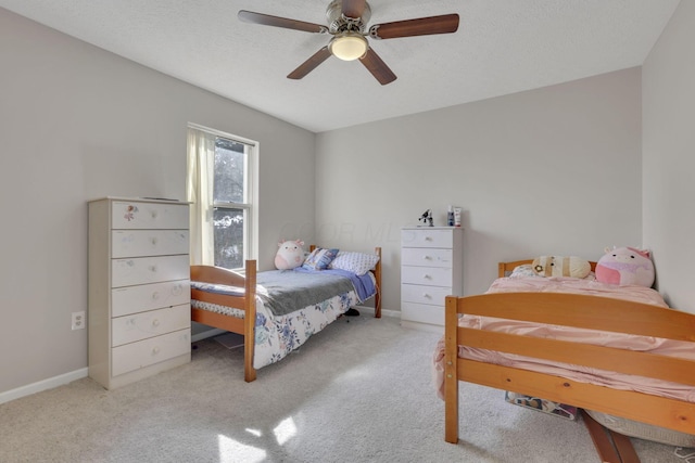 bedroom featuring a textured ceiling, baseboards, carpet, and a ceiling fan