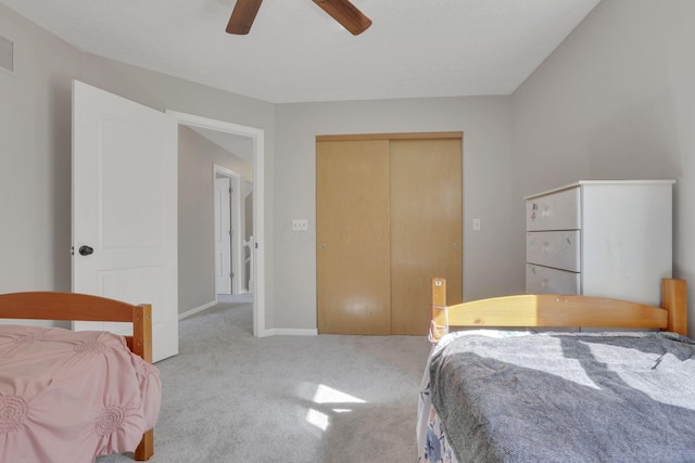 bedroom with a ceiling fan, visible vents, carpet, baseboards, and a closet