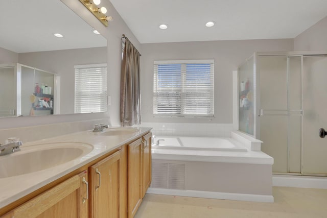 full bathroom featuring a shower stall, a bath, and a sink