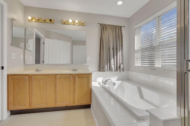 full bathroom featuring a sink, a garden tub, and double vanity