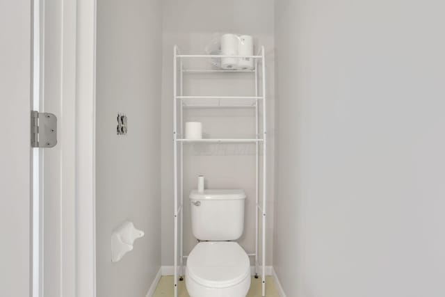 bathroom with toilet and baseboards