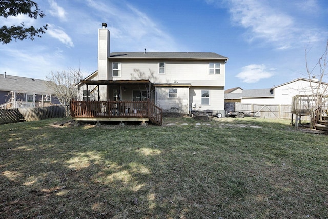 back of property featuring a deck, a yard, a fenced backyard, and a chimney