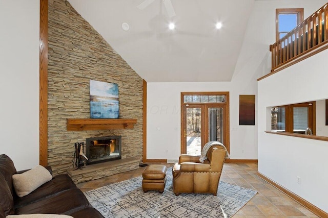 tiled living room featuring a fireplace, high vaulted ceiling, baseboards, and a ceiling fan