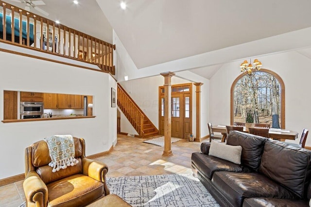 living room with baseboards, high vaulted ceiling, stairs, and an inviting chandelier