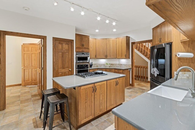 kitchen with a breakfast bar, smart refrigerator, a sink, a center island, and stainless steel gas stovetop