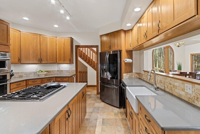 kitchen featuring light countertops, decorative backsplash, recessed lighting, appliances with stainless steel finishes, and a sink