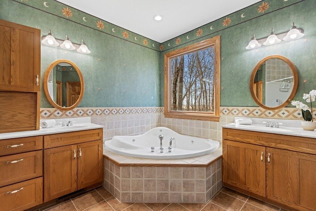 bathroom with a sink, a garden tub, and two vanities