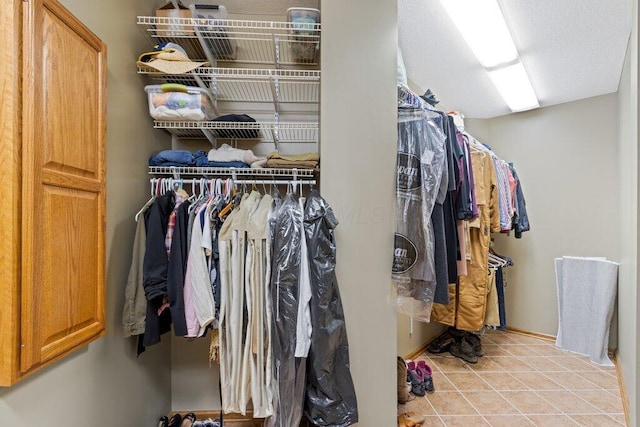 walk in closet with light tile patterned floors