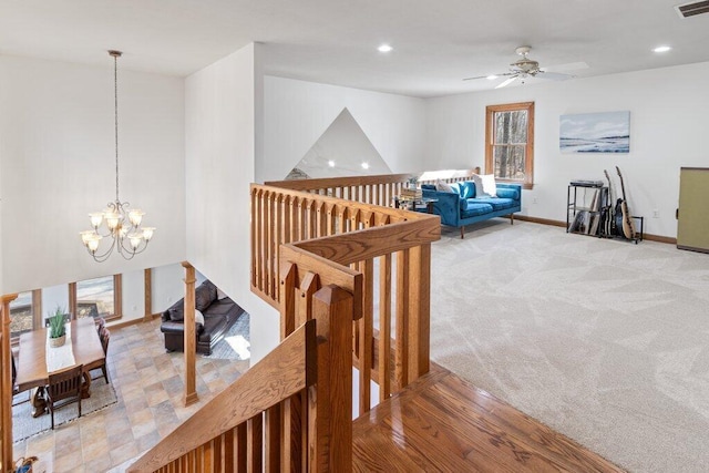 stairs featuring visible vents, baseboards, carpet floors, recessed lighting, and ceiling fan with notable chandelier