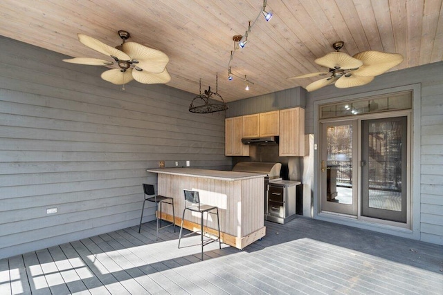 kitchen featuring track lighting, light brown cabinetry, a peninsula, wooden ceiling, and wood walls