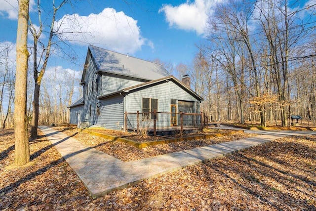 view of home's exterior with a deck and a chimney